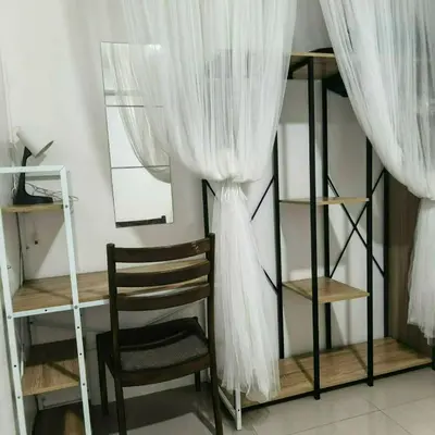 a desk and a chair in a room with a curtain at Shore Recidences Mall Of Asia Cullen in Manila