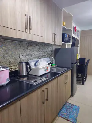 a kitchen with a sink and a refrigerator at Shore Recidences Mall Of Asia Cullen in Manila