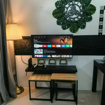 a room with a table and a clock on the wall at Shore Recidences Mall Of Asia Cullen in Manila