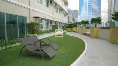 a patio with a bench and grass in a building at Aludia's Dreamplace in Manila
