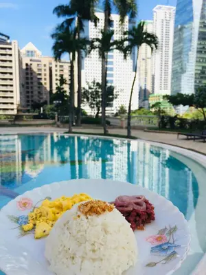 a plate of food on a table in front of a pool at Aludia's Dreamplace in Manila
