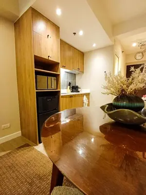 a kitchen with a wooden table and a dining room at The Florentine Suite in Manila