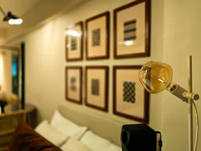 a room with a bed and a lamp and framed pictures at The Florentine Suite in Manila
