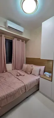 a bedroom with a large bed with pink sheets at The Shore 3 Chic Suite in Manila