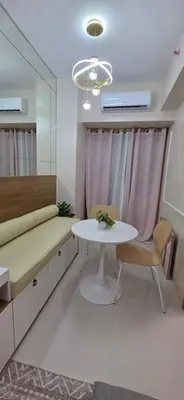 a room with a table and a bed and a chair at The Shore 3 Chic Suite in Manila