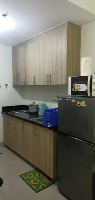 a kitchen with a black refrigerator and wooden cabinets at SM Mall of Asia Shore2 Tower2 Nano Nap&Go in Manila