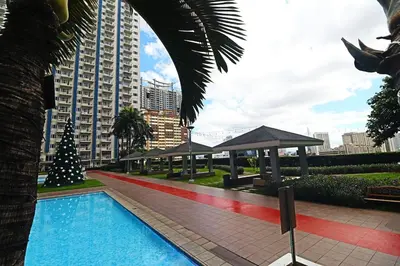 a swimming pool with a christmas tree next to a building at Comfy 1BR Self Check-In at Light Residences in Manila