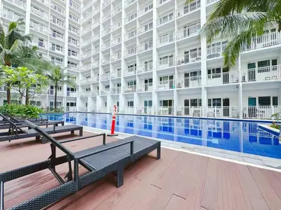 a large apartment building with a swimming pool and benches at City Center Near Mall BIG 2 BEDROOM 2 RESTROOM City View Family-Friendly SHORE 2 RESIDENCE Tower 1 in Manila