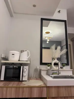a kitchen with a microwave and a sink and a mirror at PaulBert's Cabins III in Manila
