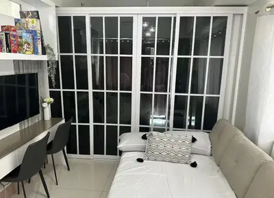 a living room with a white couch in front of a large window at Spacious 2BR in Shore3 in Manila