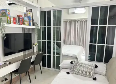 a living room with a desk and a television at Spacious 2BR in Shore3 in Manila