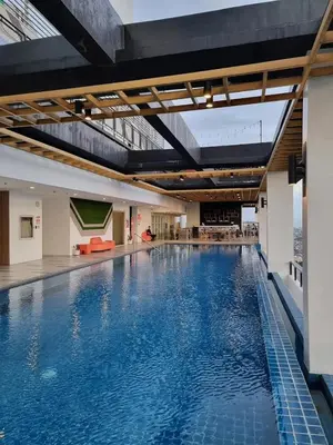 a large pool with blue water in a building at The Residences BCCT in Manila