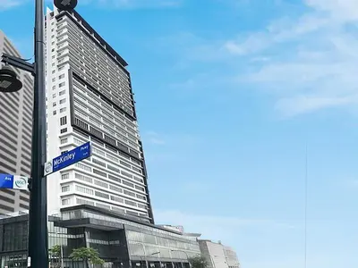 a street sign in front of a tall building at The Residences BCCT in Manila