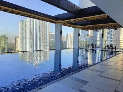 a swimming pool on the roof of a building with a city skyline at The Residences BCCT in Manila