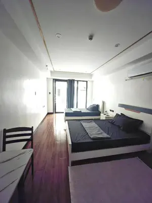 a bedroom with two beds in a room with a wooden floor at Star Steward Guest Services in Manila