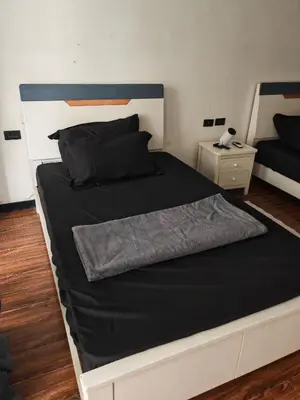 a bedroom with a large bed with a black comforter at Star Steward Guest Services in Manila