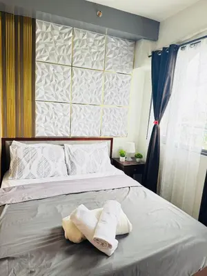 a bedroom with two towels on a bed at Shore 2 Residence Erlinda suite in Manila