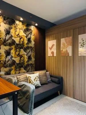 a living room with a couch and a flower wall at Shore 2 Residence Erlinda suite in Manila