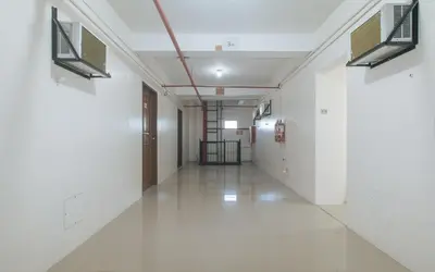 an empty hallway in a building with white walls at RedDoorz at FCCG GoldMoon Boutique Hotel in Manila