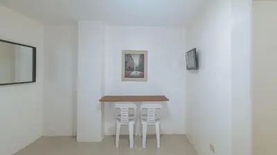 a table and two white chairs in a room at RedDoorz at FCCG GoldMoon Boutique Hotel in Manila