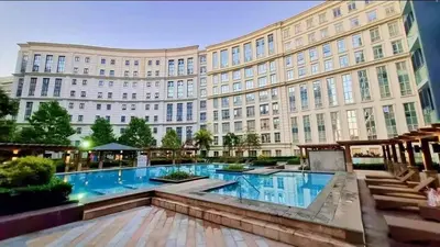a large building with a large swimming pool in front of it at Eighty One Newport Blvd Condo near NAIA3 in Manila