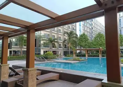 a swimming pool with a pergola next to a building at Eighty One Newport Blvd Condo near NAIA3 in Manila