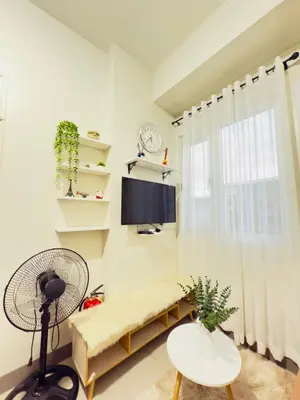a living room with a tv and a window at Cozy Condo at SMDC Charm Cainta in Manila