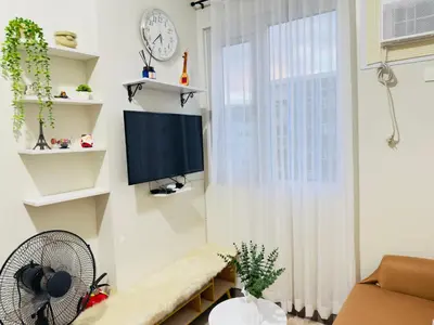 a living room with a tv and a window at Cozy Condo at SMDC Charm Cainta in Manila
