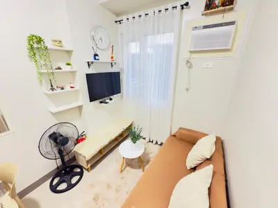 a living room with a couch and a tv at Cozy Condo at SMDC Charm Cainta in Manila