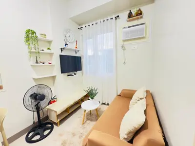 a living room with a couch and a window at Cozy Condo at SMDC Charm Cainta in Manila
