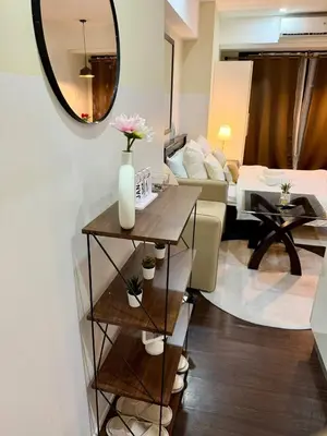 a living room with a table and a mirror at Deluxe Room with Pool View Unit in Poblacion in Manila