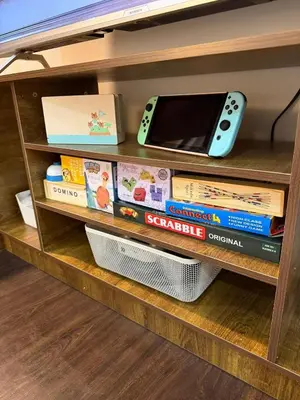 a book shelf with a remote control and books at Deluxe Room with Pool View Unit in Poblacion in Manila