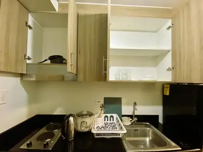 a kitchen counter with a sink and a sink at Ameera Condo Stay in Manila