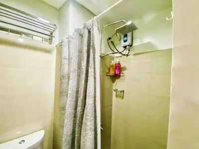 a bathroom with a shower with a white shower curtain at Ameera Condo Stay in Manila
