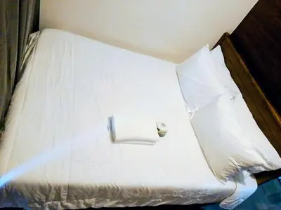 a white bed with white sheets and pillows at Budget-Friendly Condo in Makati in Manila