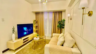 a living room with a couch and a television at Brand New Cozy 2 BR unit in Pasig in Manila