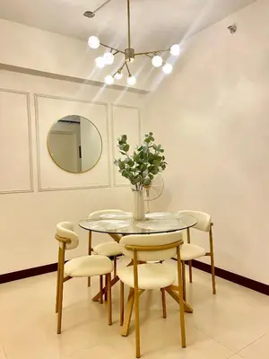 a dining room with a table and chairs and a mirror at Brand New Cozy 2 BR unit in Pasig in Manila