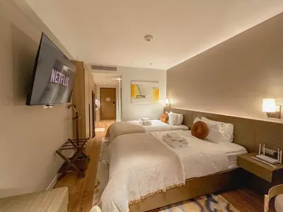 a hotel room with two beds and a flat screen tv at Premium Twin Suite at Novotel Acqua - City View in Manila