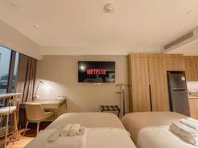 a hotel room with two beds and a tv on the wall at Premium Twin Suite at Novotel Acqua - City View in Manila