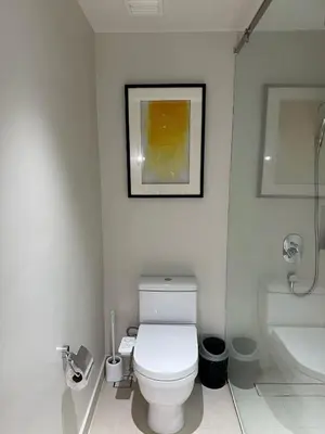 a white bathroom with a toilet and a sink at Premium Twin Suite at Novotel Acqua - City View in Manila