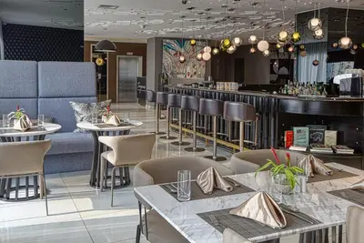 a restaurant with tables and chairs and a bar at Premium Twin Suite at Novotel Acqua - City View in Manila