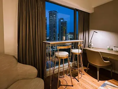 a hotel room with a desk and a view of a city at Premium Twin Suite at Novotel Acqua - City View in Manila