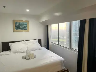 a bedroom with a bed with a teddy bear on it at Luxury 2BR with Stunning Skyline Views in BGC in Manila