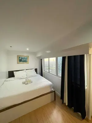 a bedroom with a bed with a stuffed animal on it at Luxury 2BR with Stunning Skyline Views in BGC in Manila
