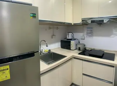 a small kitchen with a sink and a microwave at Luxury 2BR with Stunning Skyline Views in BGC in Manila