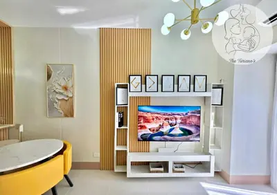 a living room with a television on a white entertainment center at The Turianos in Manila
