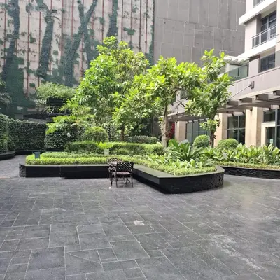 a bench in a courtyard with trees and plants at STAYLUXIA BOUTIQUE HOTEL KNIGHTSBRIDGE Pool Netflix Free Amenities in Manila
