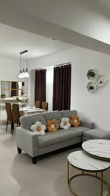 a living room with a gray couch and tables at Condo Unit in Parañaque by Casa Esplanade in Manila