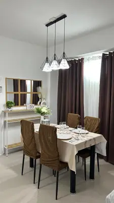 a dining room with a white table and chairs at Condo Unit in Parañaque by Casa Esplanade in Manila