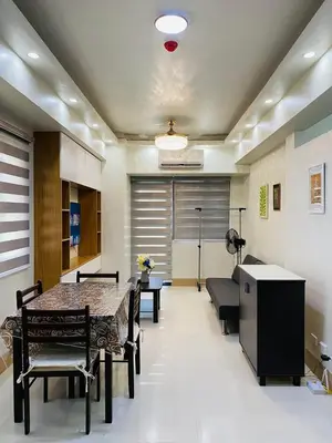 a room with a table and chairs and a couch at Shore 3 Residences in Manila